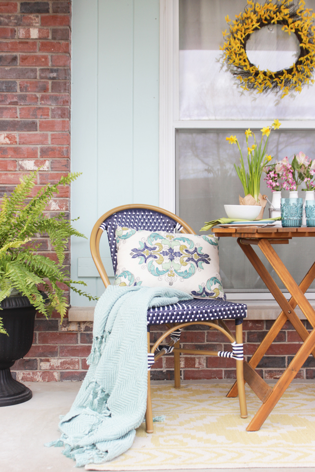Navy Outdoor Bistro chair with aqua throw and pattern pillow