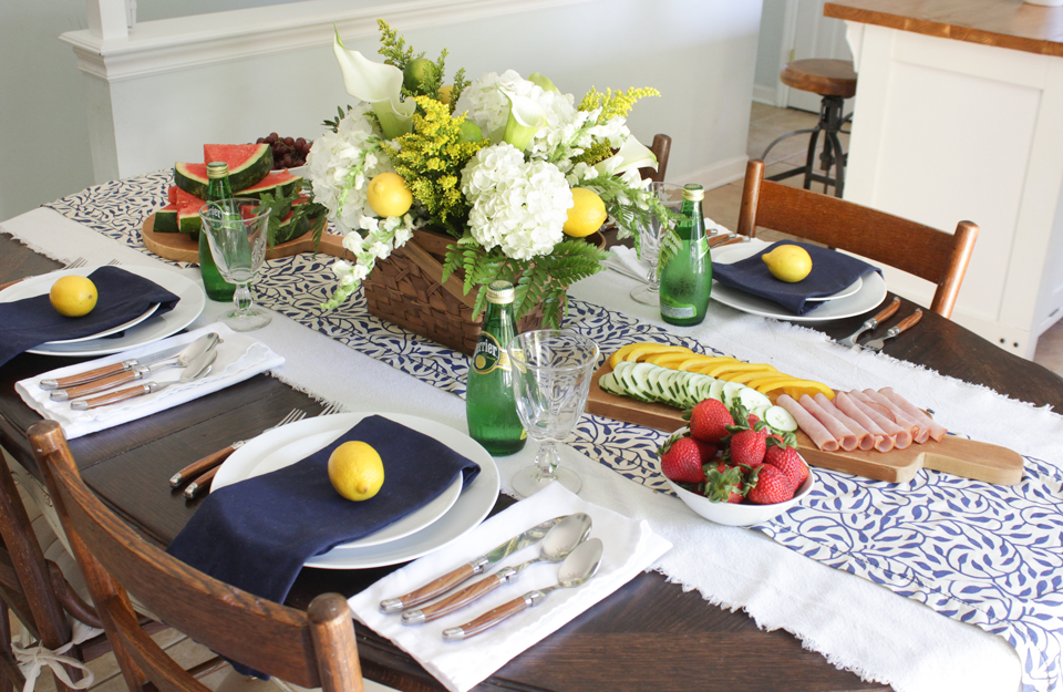 Blue and white runner, navy napkins, white dishes, french flatware, lemons, and fresh flowers