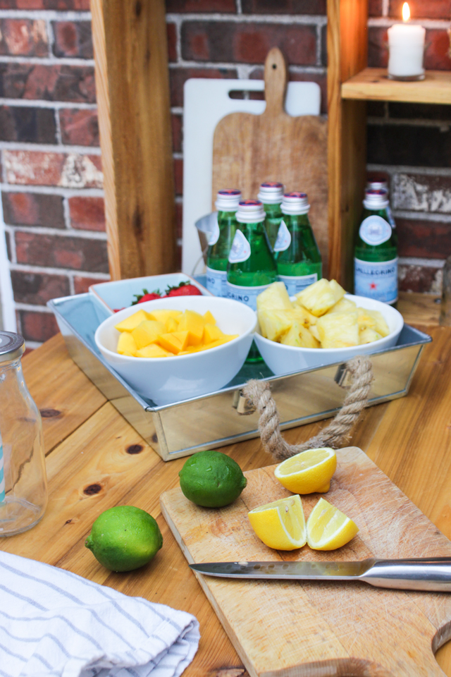 Cut lemons and bowls of fresh fruit for a fruit-kebob station