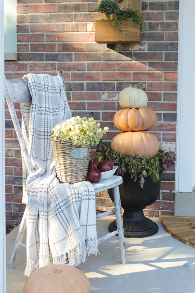 Farmhouse chair, flannel throw, and pumpkin topiary for fall