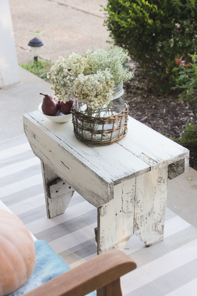 Chippy wooden stool as a table on a fall front porch