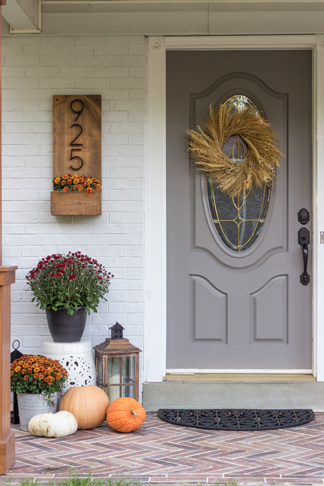Fall front door dressed up with pumpkins, mums, and lanterns