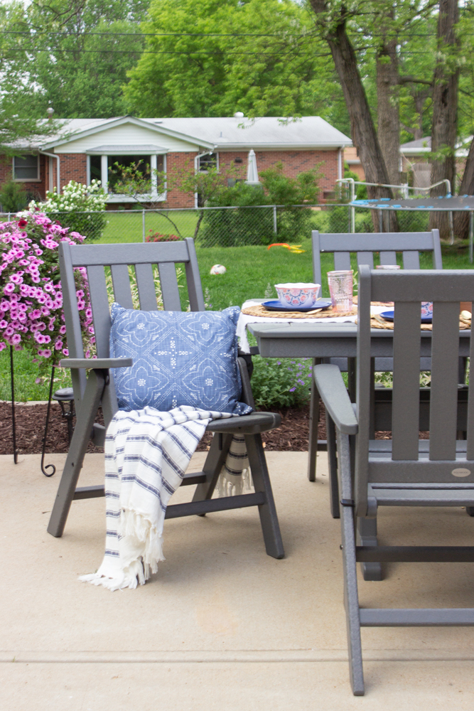 Navy pillow, striped throw, gray outdoor dining furniture