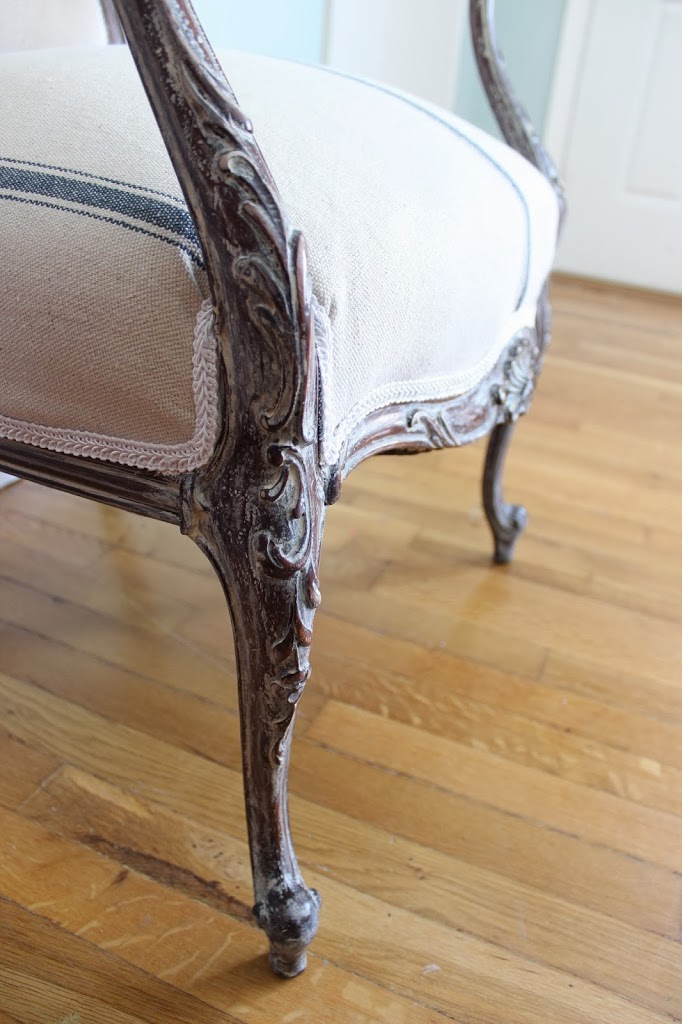 White washed frame of french chair, reupholstered with grain sack fabric and white trim