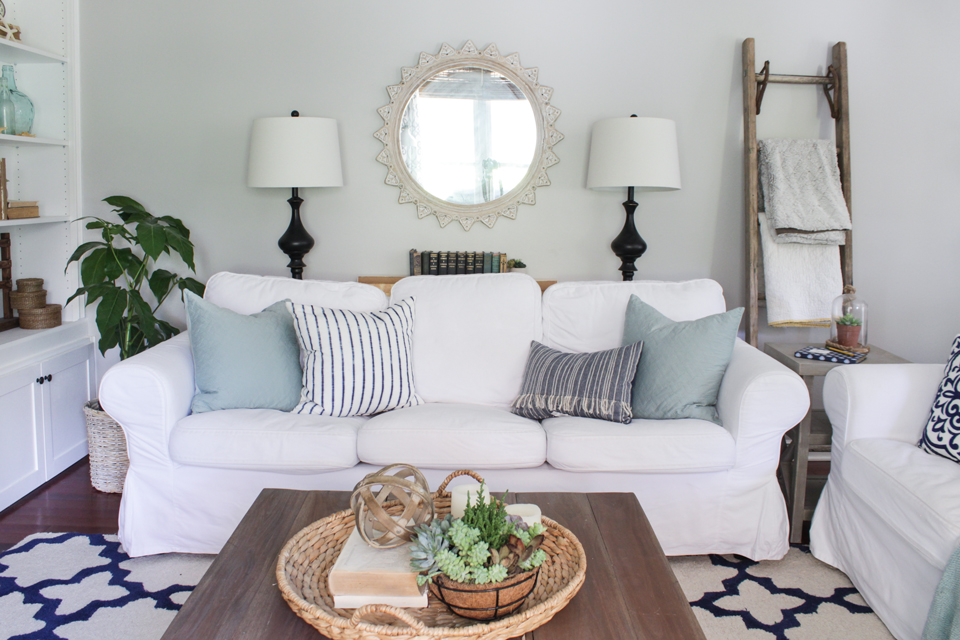 White slipcovered sofas with aqua and navy accents in summer living room