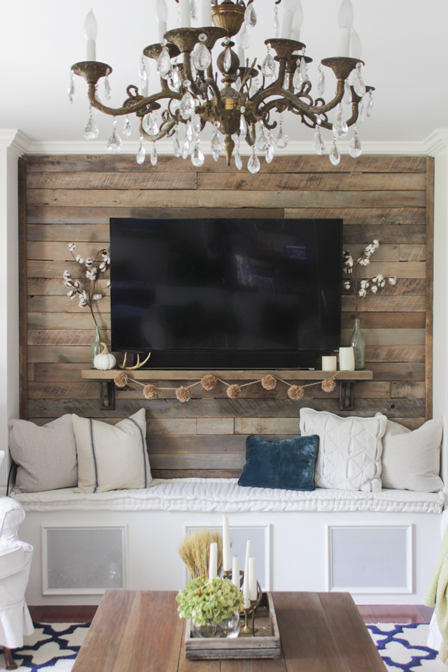 Pallet accent wall with simple fall touches, and a brass chandelier